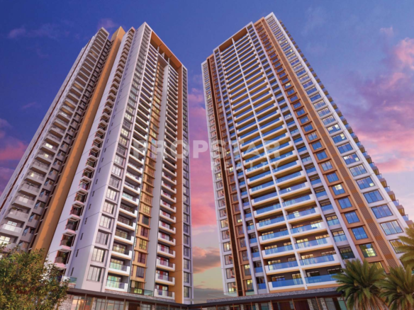 Two tall modern residential towers leaning toward each other against a pink-and-blue sunset sky in the background.