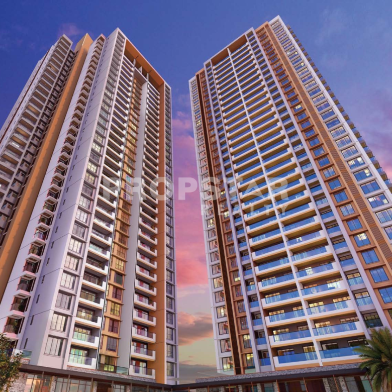 Two tall modern residential towers leaning toward each other against a pink-and-blue sunset sky in the background.